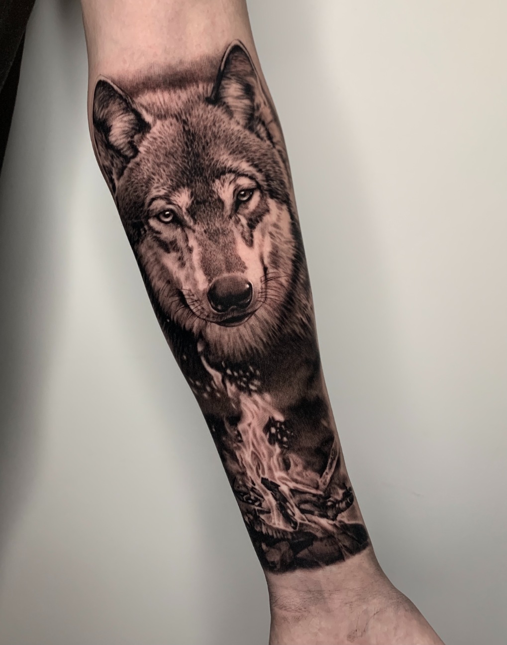 Wolf-Tattoo mit Flamme am Unterarm Wolf-Tattoo mit Flamme am Unterarm