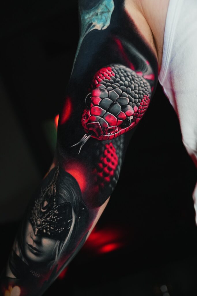 Trend-Tattoo einer Schlange in Farbe im 3D Realistic Stil auf dem Oberarm eines Mannes