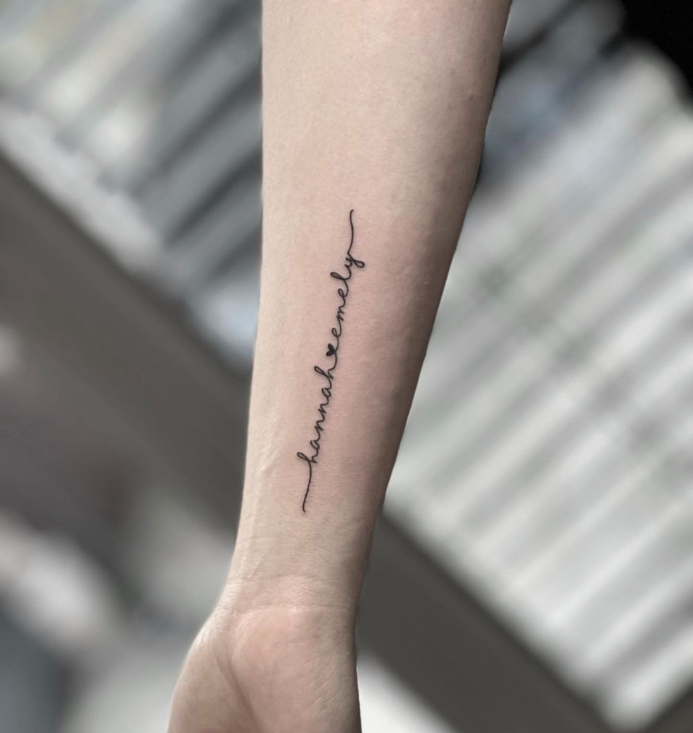 Schriftzug-Tattoo am Unterarm mit klarer Typografie Schriftzug-Tattoo am Unterarm mit klarer Typografie