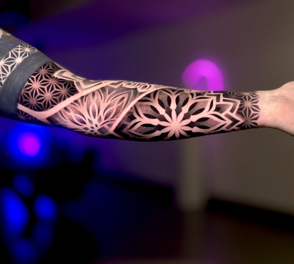 Geometrisches Dotwork-Sleeve mit Mandala- und Blütenmustern am Unterarm